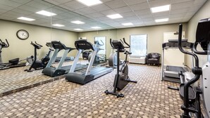 Un gimnasio con cintas de correr, elípticas y bicicletas estáticas.