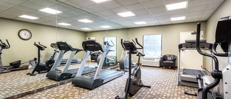 A gym with treadmills, elliptical machines, and stationary bikes.