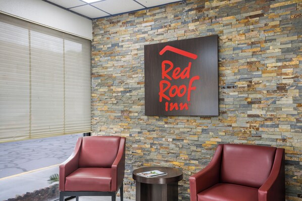A Red Roof Inn with a stone wall and two leather chairs. - Red Roof Inn Savannah - Southside/Midtown (Savannah)