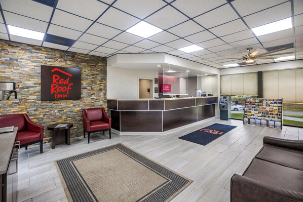 A Red Roof Inn lobby with a reception desk, seating area, and a coffee machine. - Red Roof Inn Savannah - Southside/Midtown (Savannah)