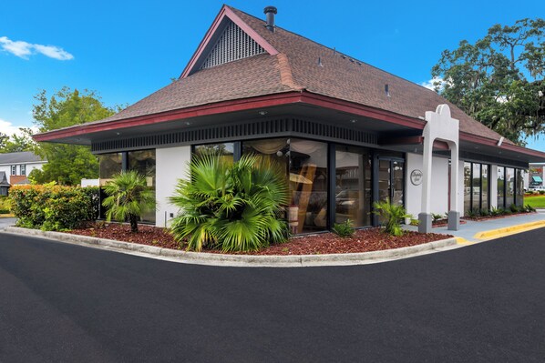 A modern building with a sloped roof, large windows, and a well-maintained garden area. - Red Roof Inn Savannah - Southside/Midtown (Savannah)