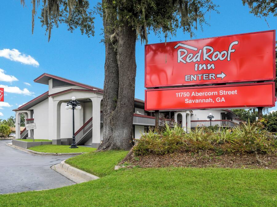 A Red Roof Inn sign with an arrow pointing to the entrance, located at 11750 Abercorn Street, Savannah, GA.