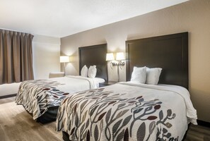 A hotel room with two beds, a desk, and a chair. - Red Roof Inn Savannah - Southside/Midtown (Savannah)