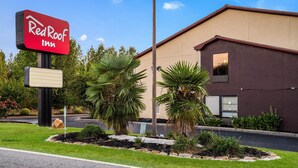 Een Red Roof Inn bord met een goed zicht op de buitenkant van het gebouw, inclusief de moderne architectuur en de omliggende beplanting.