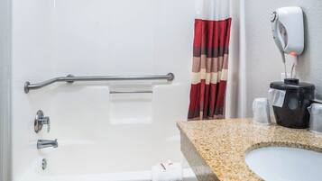 Ein Badezimmer mit einer Badewanne, einer Haltestange, einem Handtuchhalter, einer Duschvorhang und einem Seifenspender sowie einer Arbeitsplatte aus Granit.