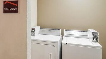 A guest laundry area with two washing machines and a sign indicating the location.