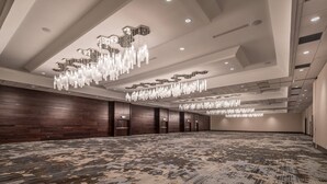 A spacious conference room with a patterned carpet, wooden panel walls, and multiple chandeliers. - Provo Marriott Hotel & Conference Center (Provo)