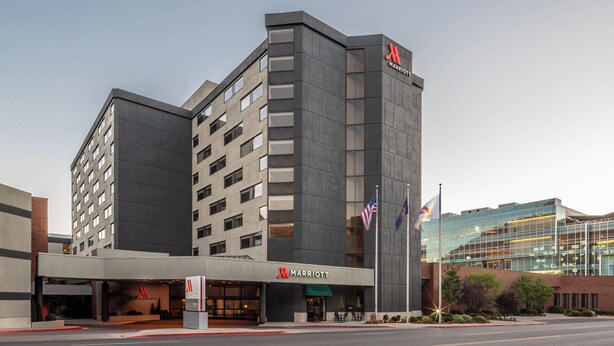 A modern Marriott hotel with a prominent 'M' logo, multiple floors, and a glass facade.