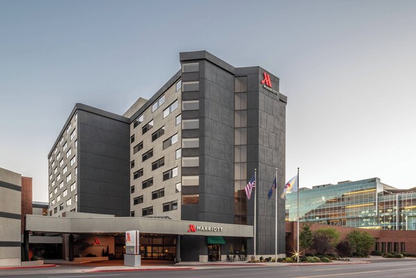 Un hôtel Marriott moderne, reconnaissable à son logo en forme de « M » bien visible, à ses nombreux étages et à sa façade en verre.