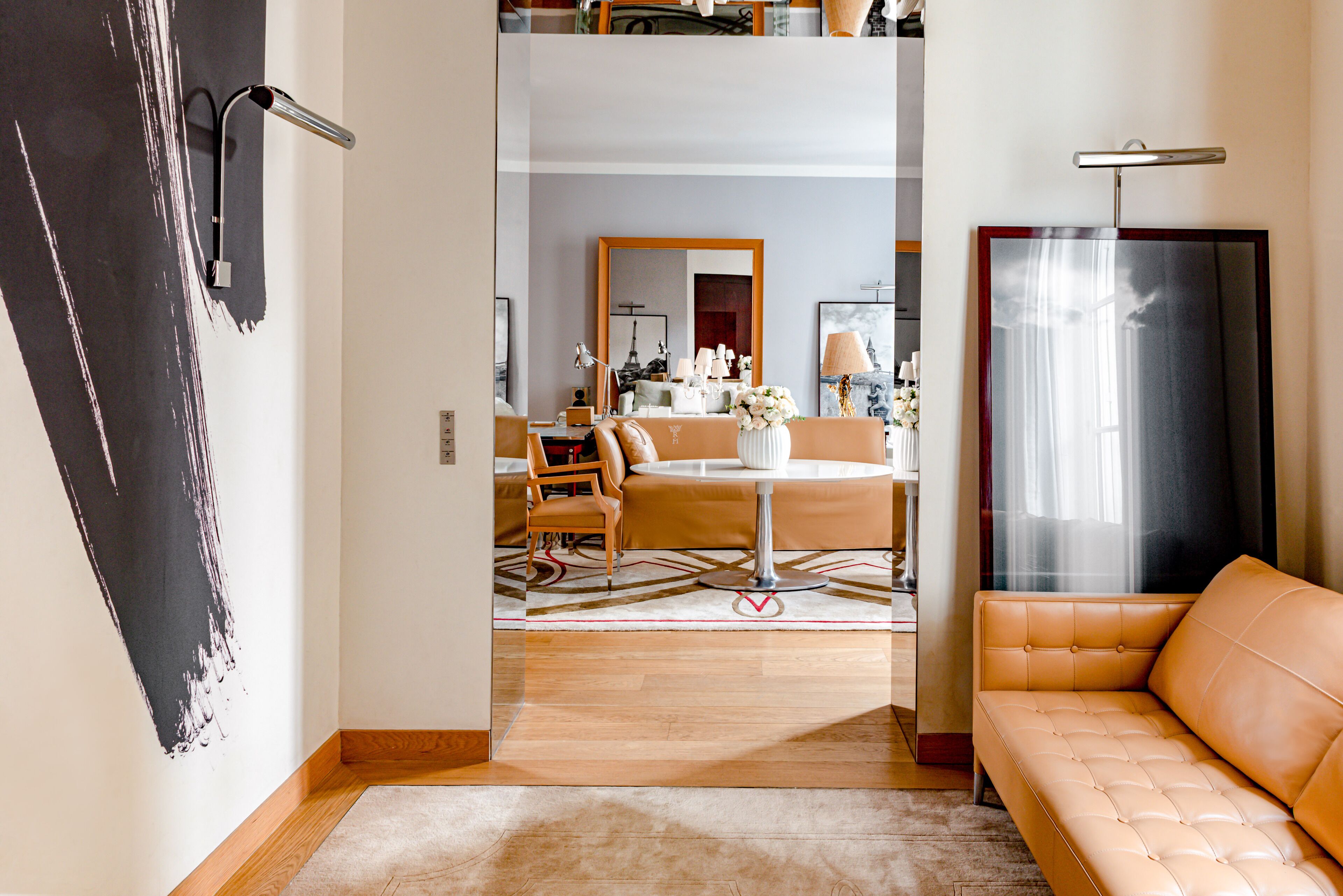 Un salon moderne avec un canapé, un coin repas comprenant une table et des chaises, et un grand miroir.