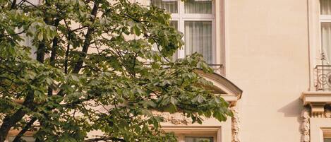 A building facade with a prominent archway, a balcony with balustrades, and a decorative lantern.