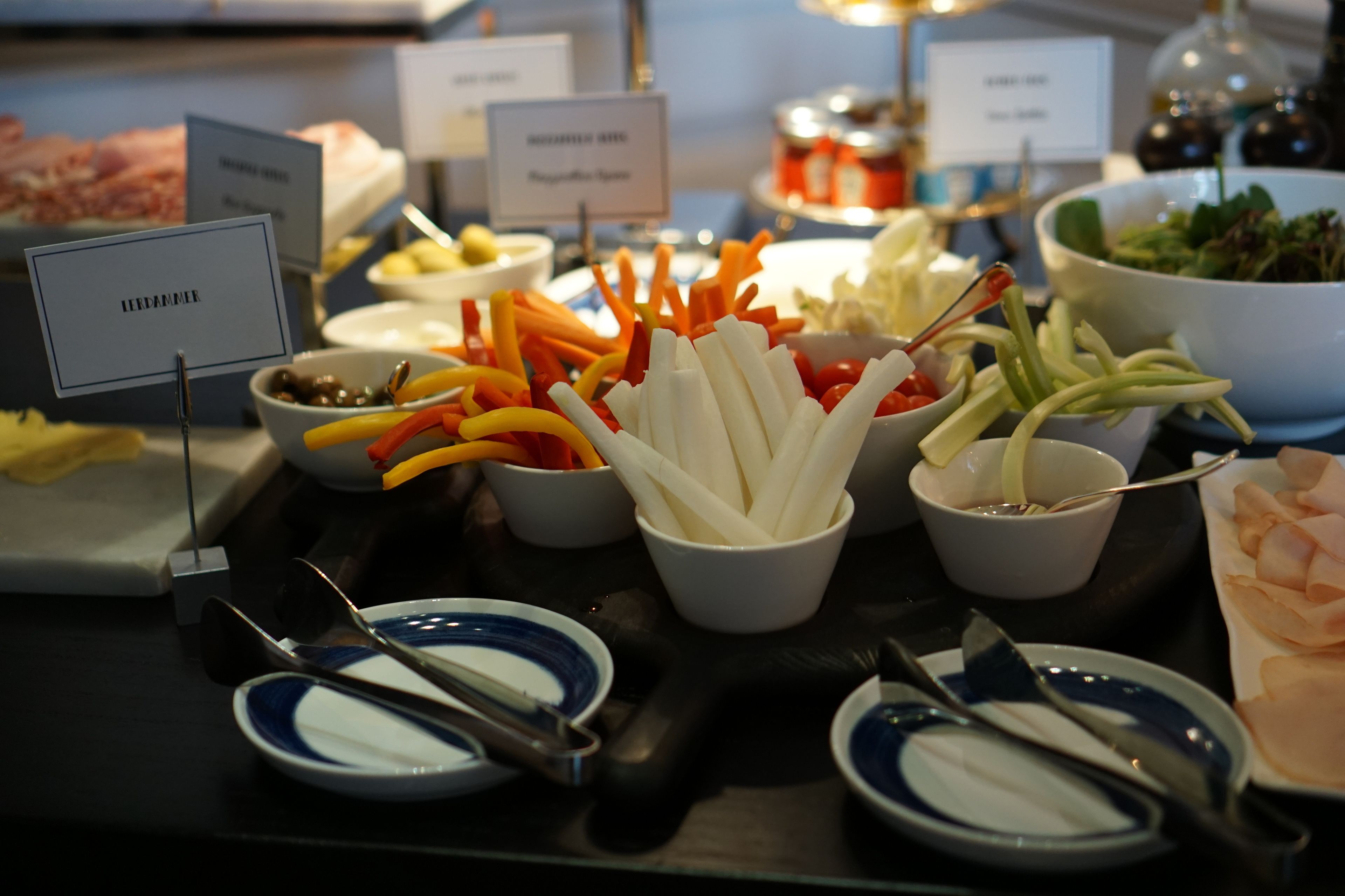 A buffet with various food items and utensils.