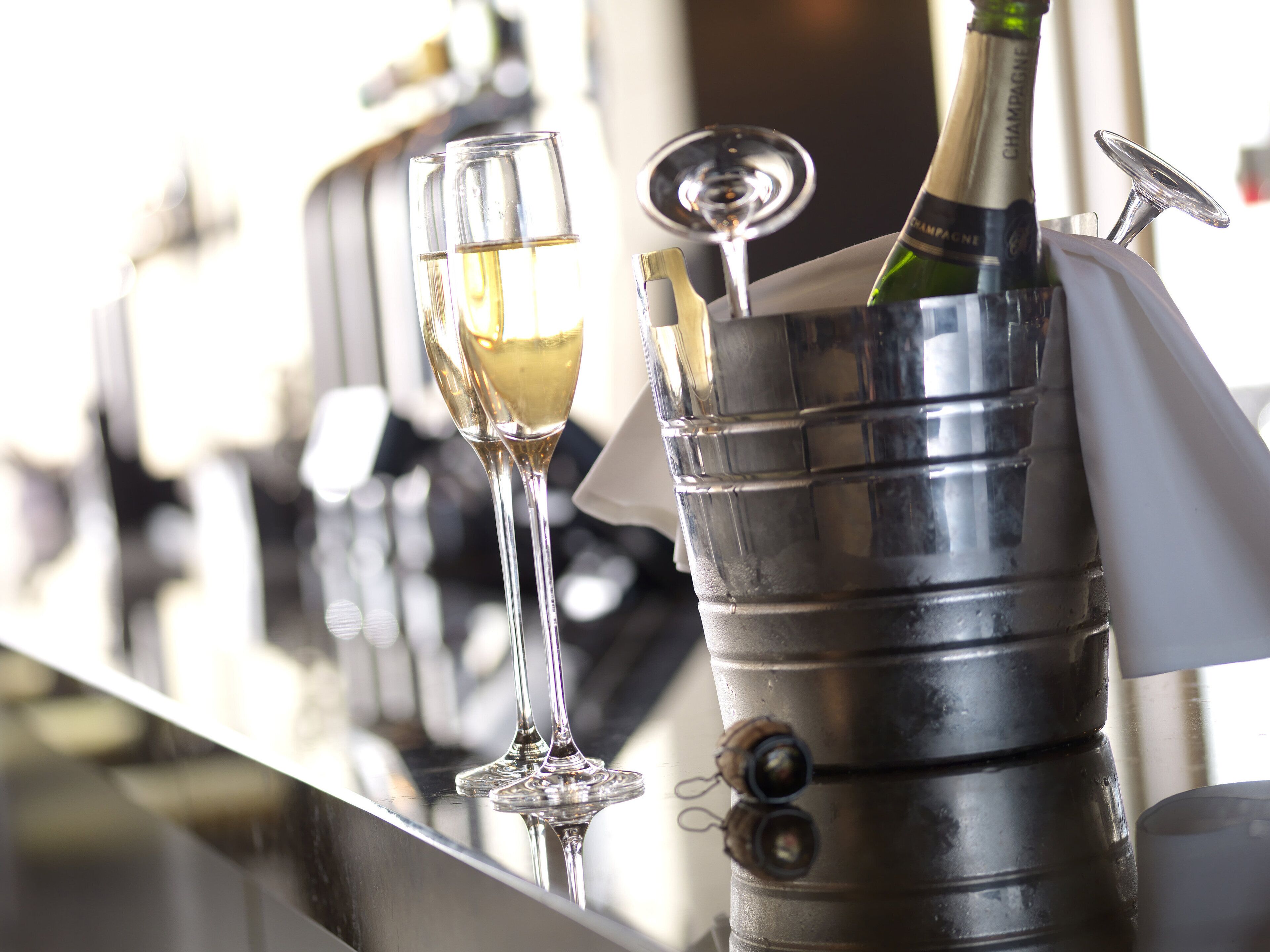 A bar setting with a champagne bottle and glasses.