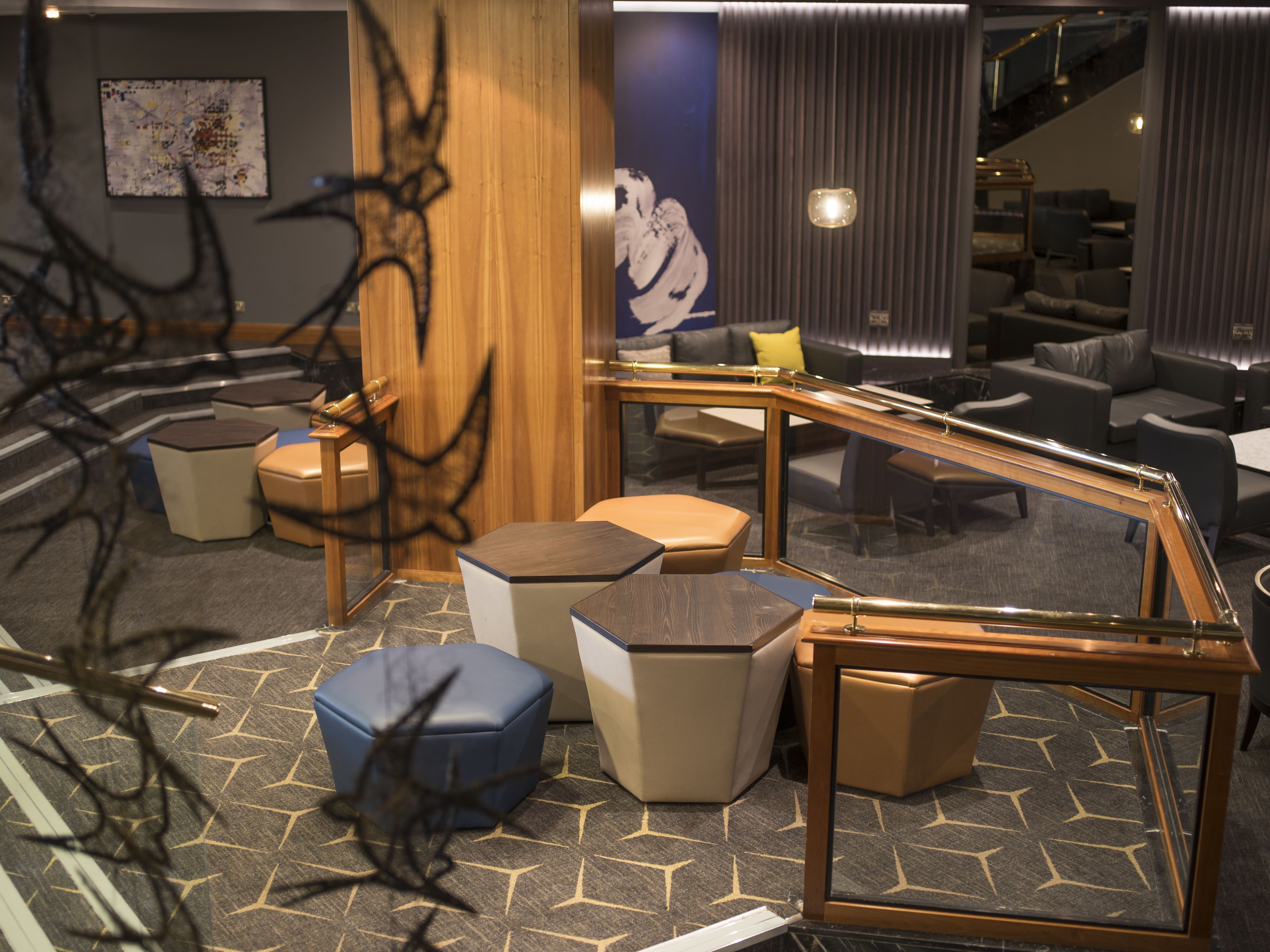 A modern interior with a curved staircase, seating areas, and a patterned floor.