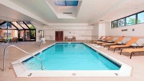 An indoor swimming pool with a clear view of the sky through the ceiling, a no diving sign, and lounge chairs along the poolside. - Courtyard by Marriott Chicago Glenview/Northbrook (Northbrook)