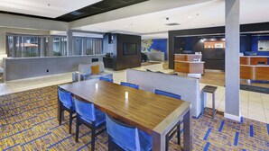 A hotel lobby with a reception desk, seating area, and a large screen. - Courtyard by Marriott Chicago Glenview/Northbrook (Northbrook)