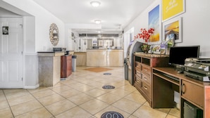 A hotel lobby with a reception desk, a kitchen area, and a seating area with a coffee machine. - Econo Lodge Daytona Beach - Speedway (Daytona Beach)