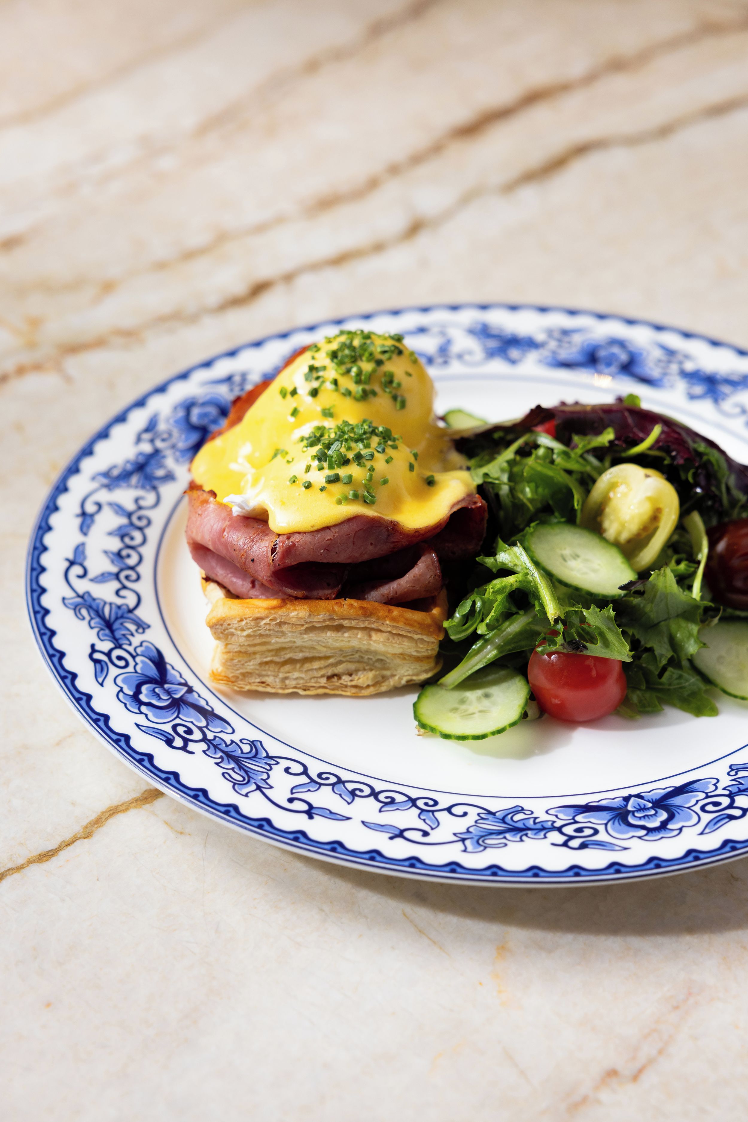 A plate with a sandwich, salad, and a decorative plate.