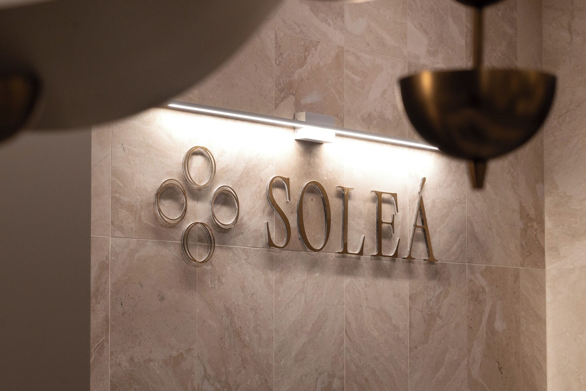 A hotel sign with the name "SOLEA" and a series of circular rings above it.