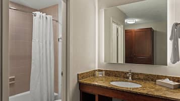 A bathroom with a shower, a sink, and a mirror.