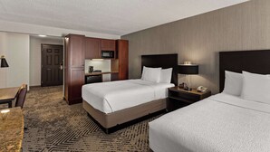 A hotel room with a bed, a desk, a microwave, and a TV.
