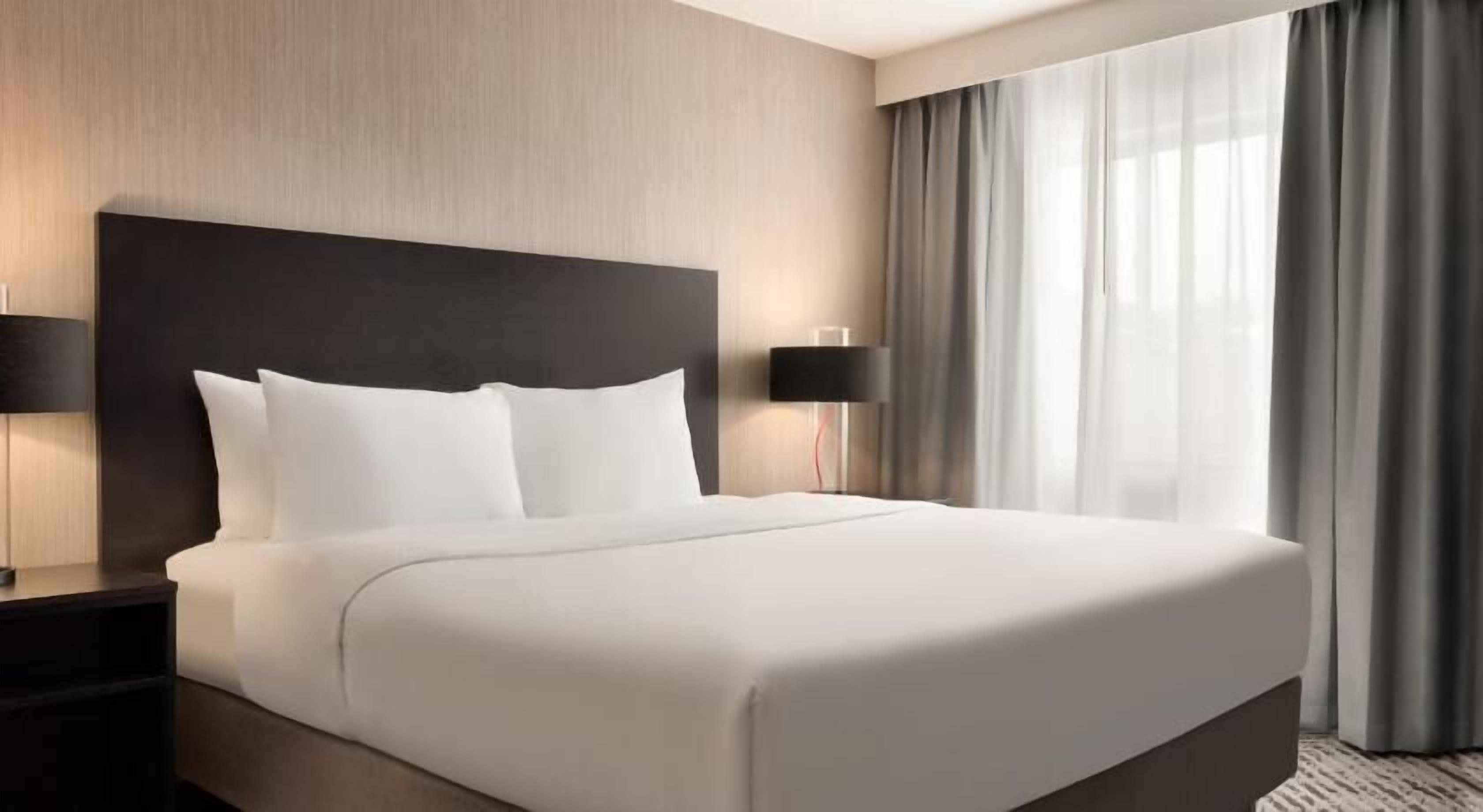 Cortinas blackout, tabla de planchar con plancha y ropa de cama 