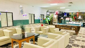 A lobby with a pool table, sofas, and a patterned carpet. - Baymont by Wyndham El Dorado (El Dorado)