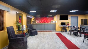 A hotel lobby with a reception desk, seating area, and a red carpet leading to a dining area. - Baymont by Wyndham El Dorado (El Dorado)