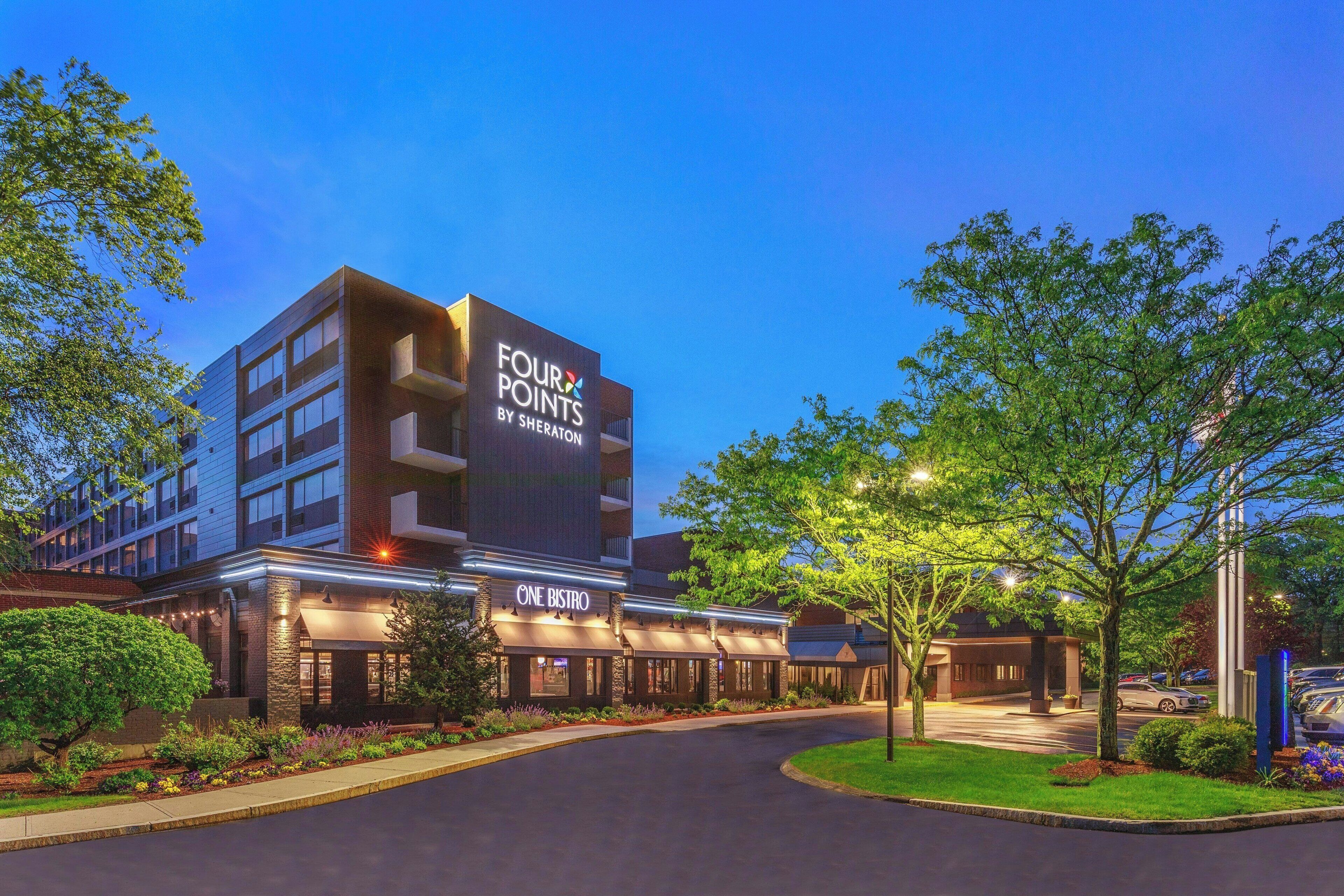Un hôtel avec une enseigne indiquant « FOUR POINTS BY SHERATON » et, en dessous, une autre enseigne indiquant « ONE BISTRO ».