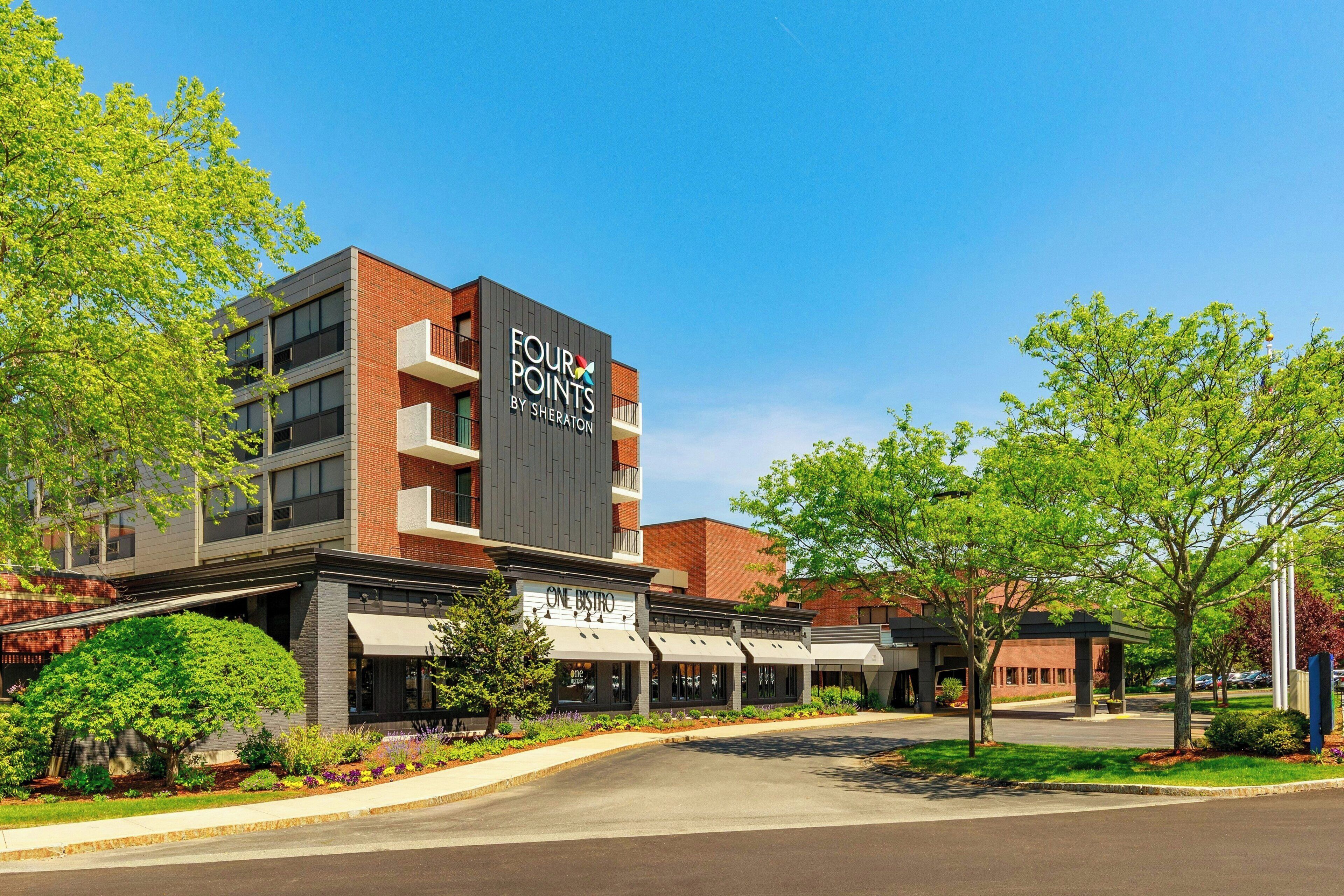 Un immeuble à plusieurs étages, sur lequel on peut voir une grande enseigne indiquant « FOUR POINTS BY SHERATON » et un restaurant appelé « ONE BISTRO ».