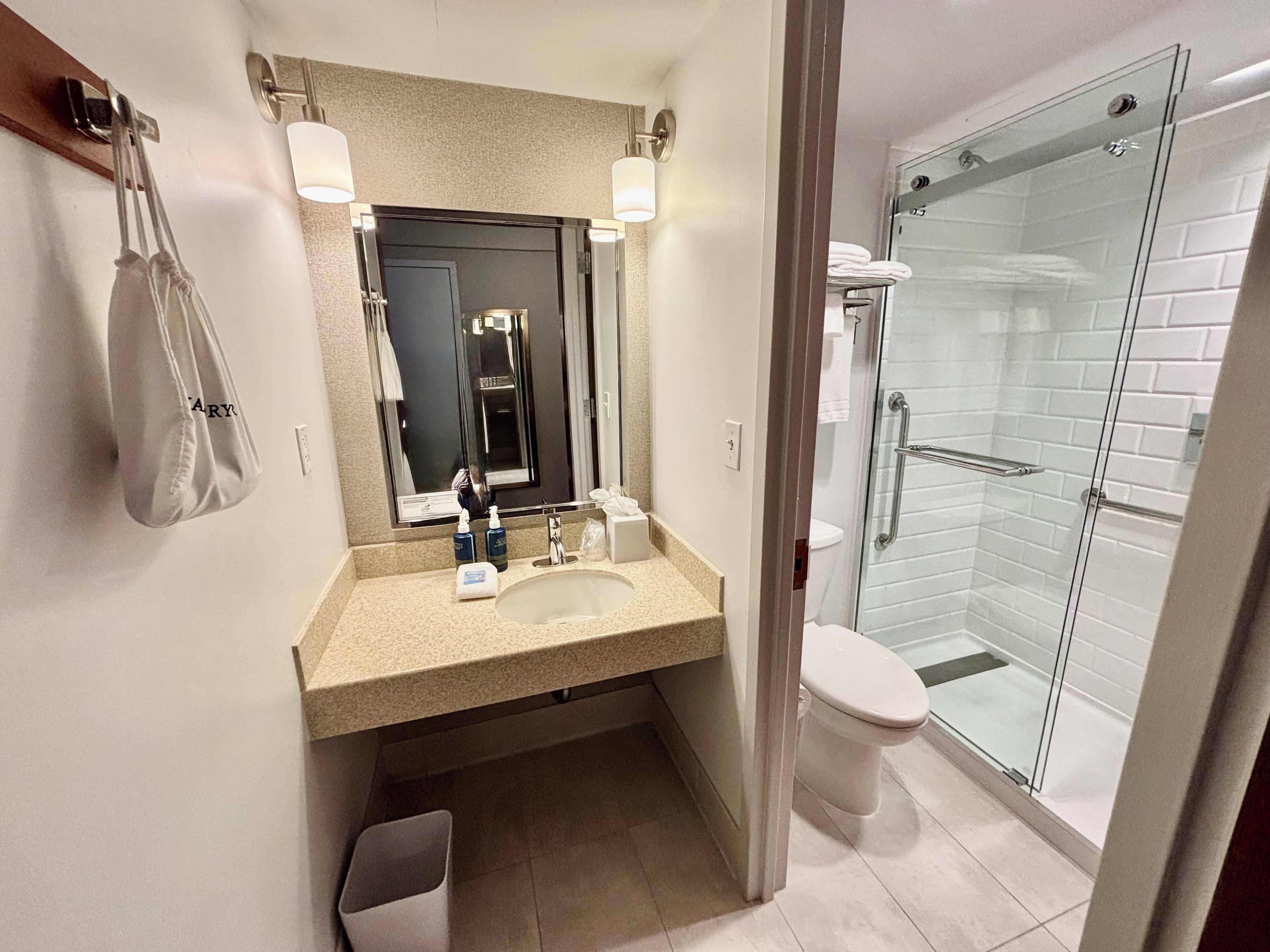 Ein modernes Badezimmer mit Waschbecken, Spiegel und Duschkabine aus Glas.