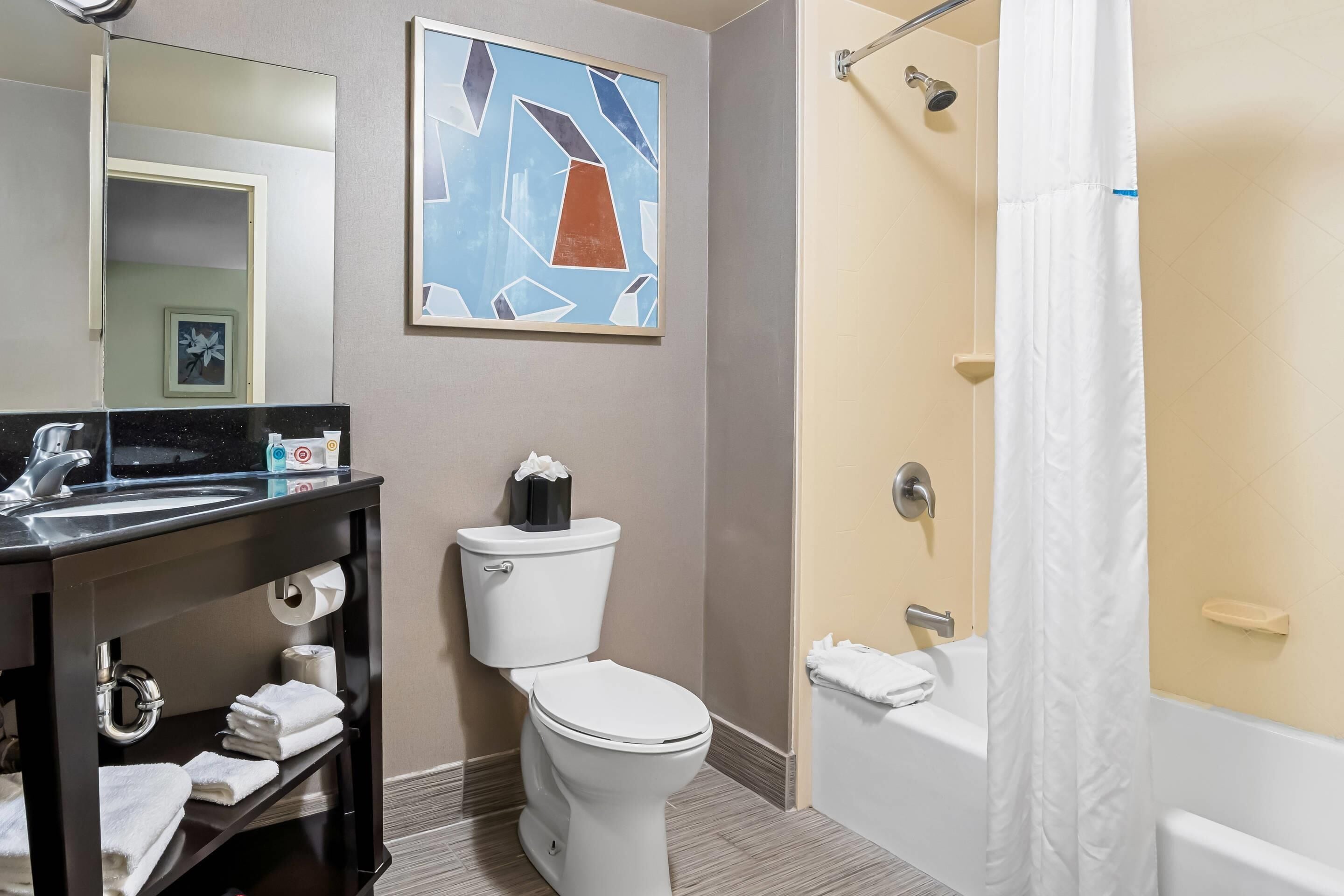 A modern bathroom with a toilet, sink, and bathtub.