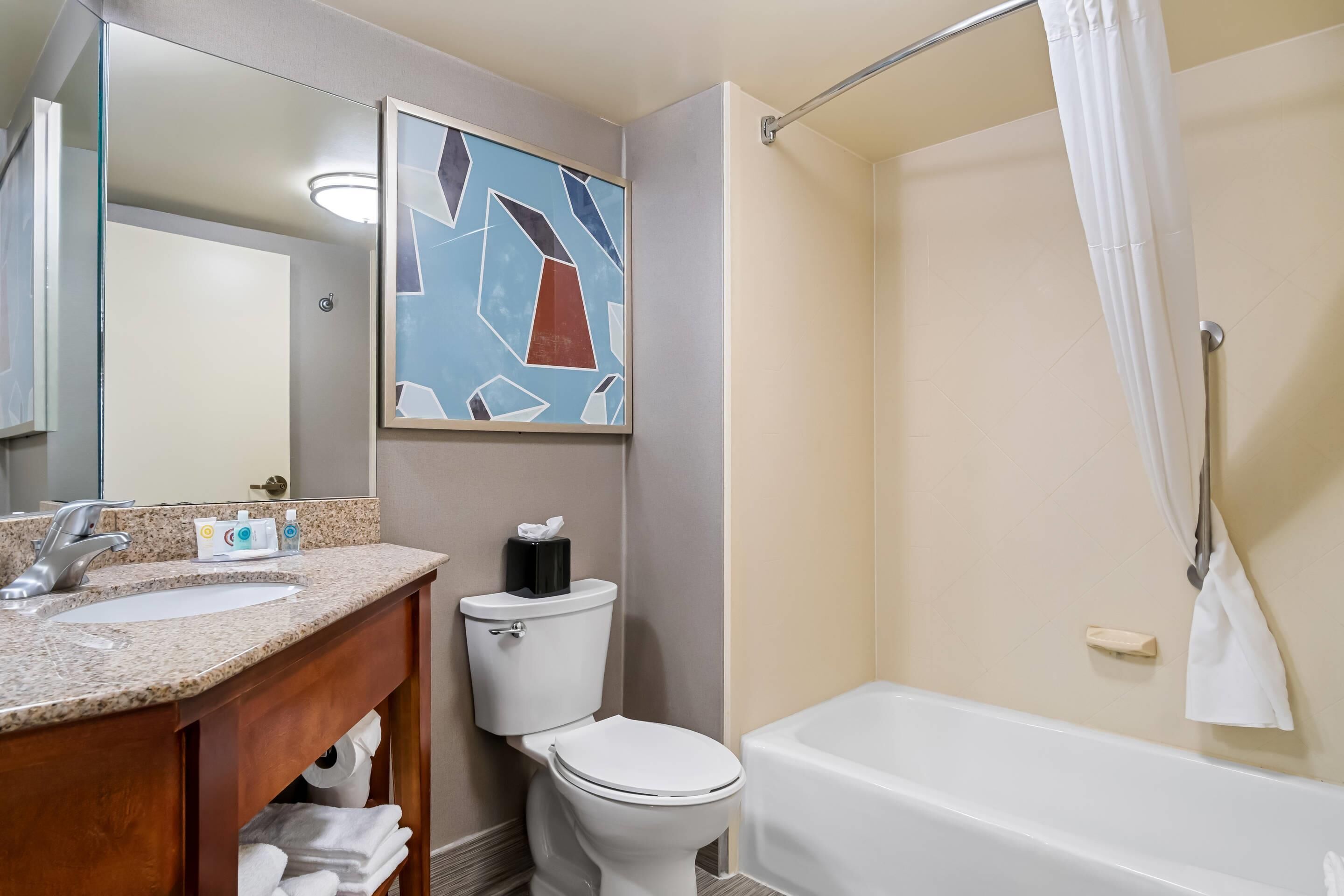 A bathroom with a sink, toilet, and bathtub.