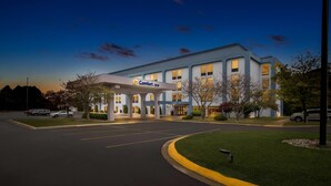 A Comfort Inn hotel with a modern design, featuring a well-lit entrance and a parking lot.