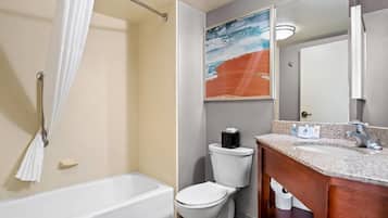 A bathroom with a bathtub, toilet, and a vanity with a sink.