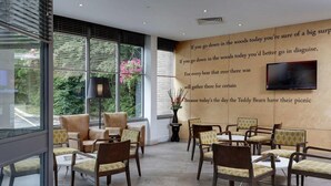 Ein moderner Wartebereich mit Ledersesseln, einem großen Fenster und einem an der Wand montierten Fernseher.