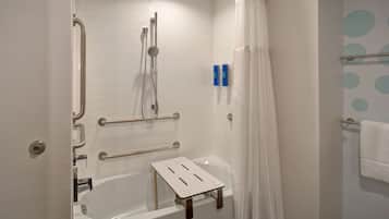 A walk-in shower with a grab bar, a handheld showerhead, and a white shower curtain.