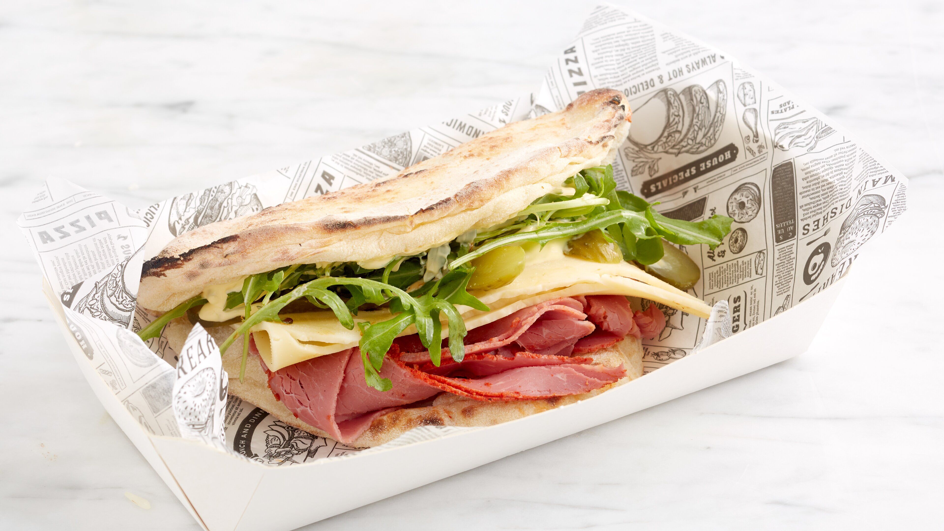 Un sandwich dans une boîte recouverte de papier.