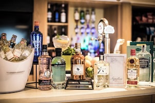 A bar counter with various bottles of gin and other spirits.