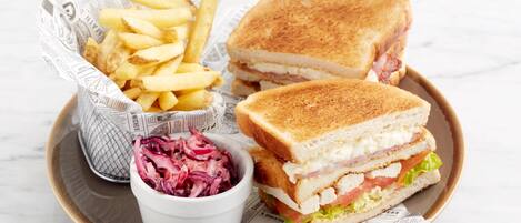 A tray with a grilled sandwich, French fries, and coleslaw.