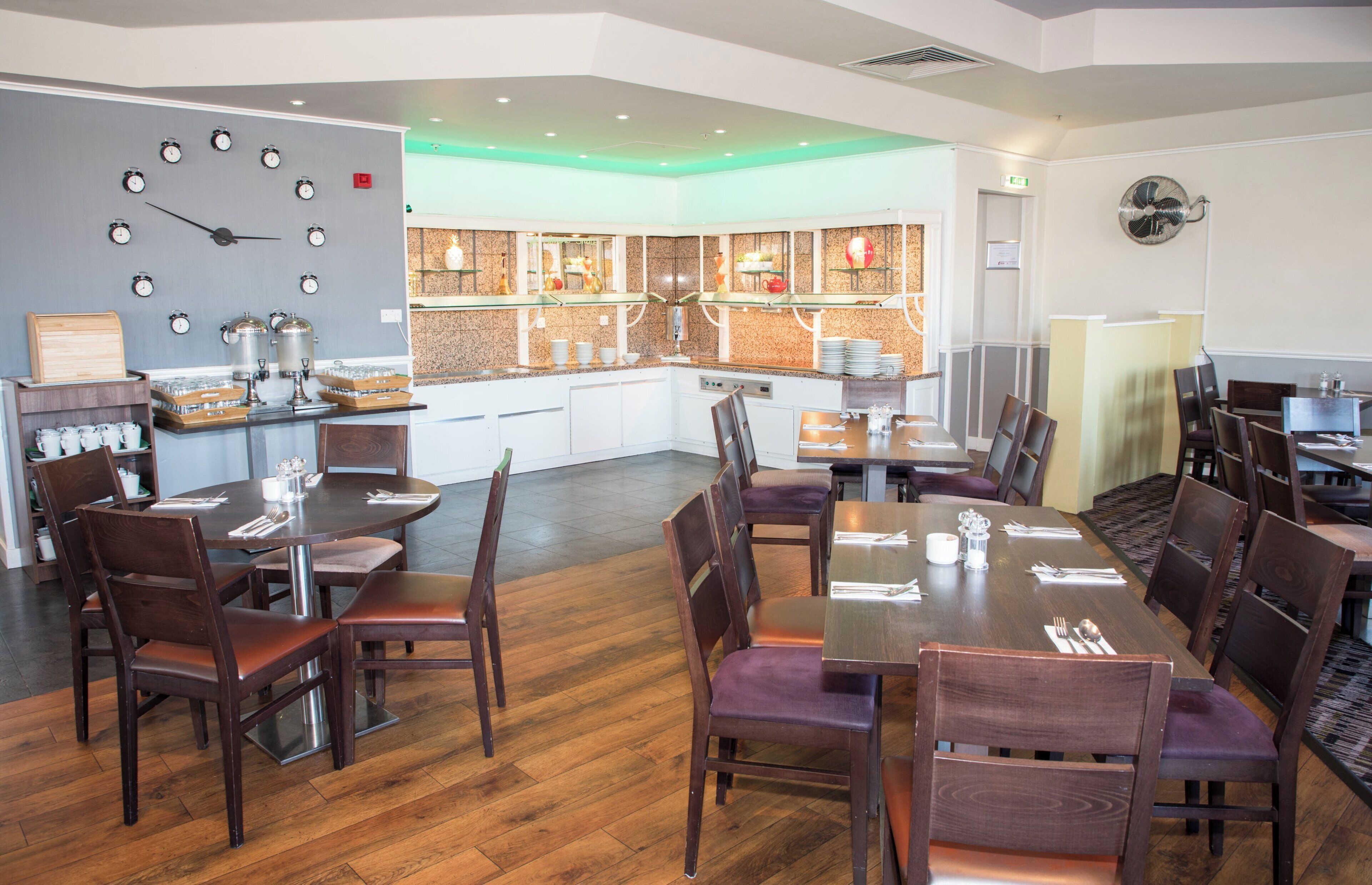 A restaurant with a bar area, multiple dining tables, and chairs.
