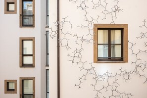 A building facade with multiple windows and a unique wall art installation. - Gallery Hotel Art - Lungarno Collection (Florence)