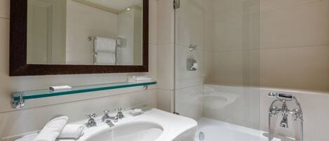 A modern bathroom with a glass shower enclosure, a white sink, and a large mirror.
