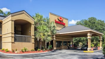 Un hotel Target con entrada techada, palmeras y estacionamiento.