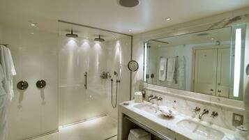 A modern bathroom with a glass-enclosed shower, a large mirror, and a dual sink vanity.