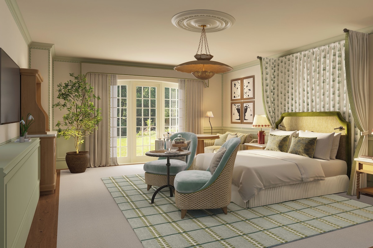 Une chambre spacieuse avec un grand lit, un coin salon et une vue sur l’extérieur.