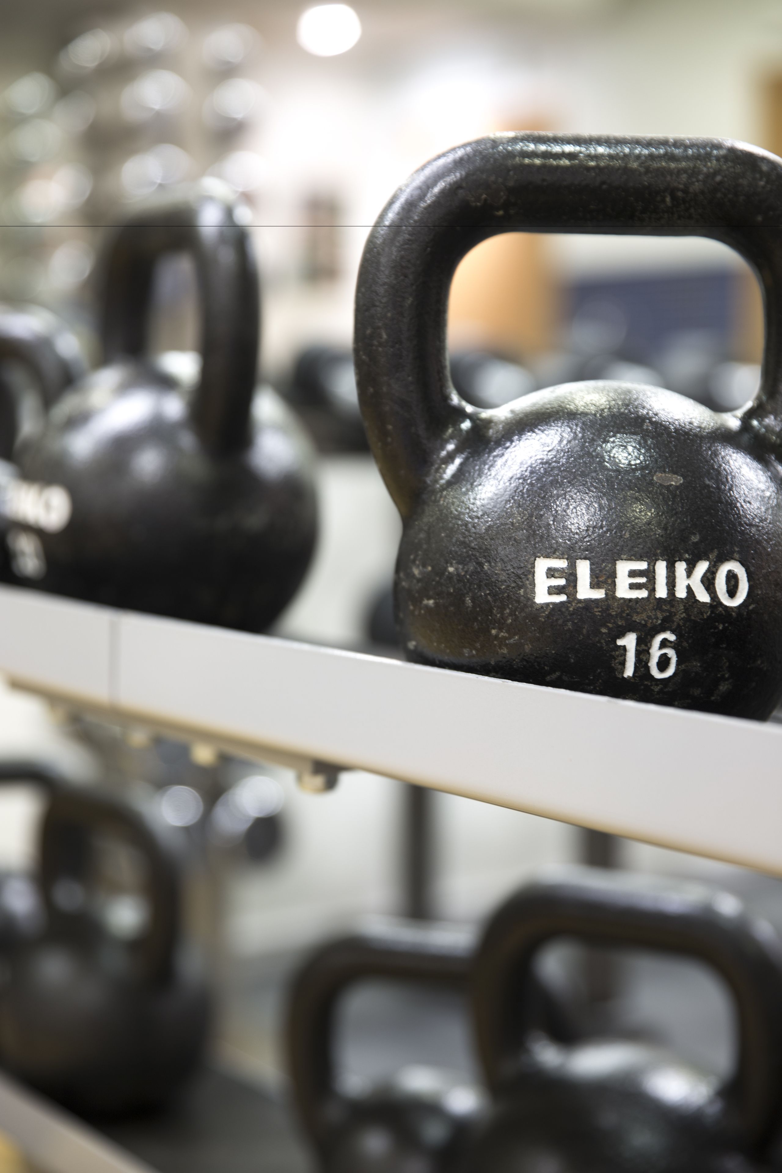 Una fila de kettelbells negros con la inscripción 'ELEIKO 16'.