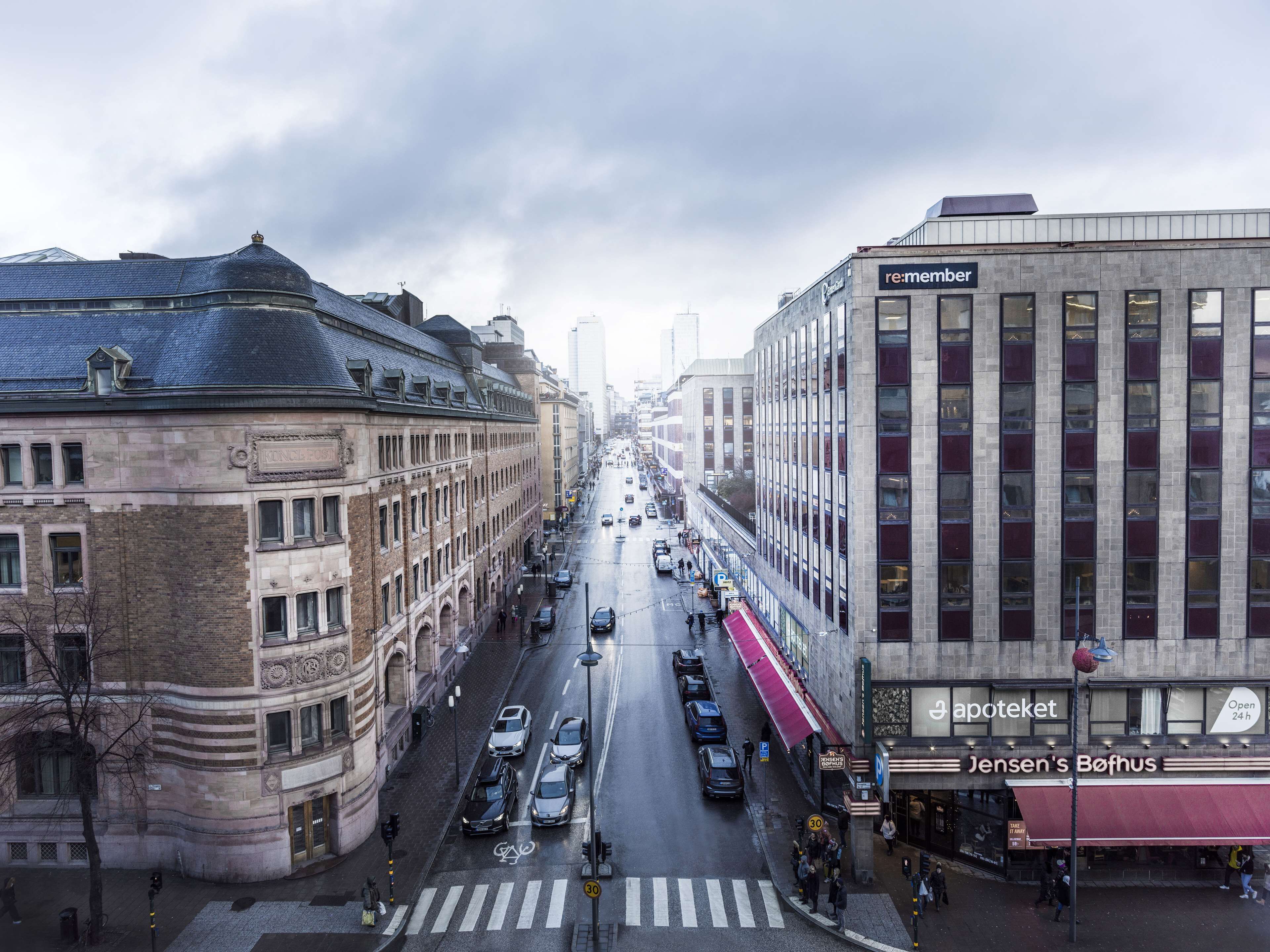 Straßenansicht mit einem Gebäude, auf dem 're:member' steht, und gegenüber davon 'Jensen's Bøhuset'.