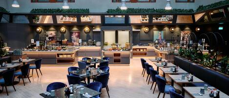 Un restaurante moderno con barra central, varias zonas de estar y vistas a la ciudad.
