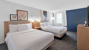 A hotel room with two beds, a desk, and a TV. - Spark by Hilton Plymouth (Plymouth)